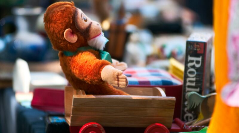 a stuffed toy monkey sitting on a stack of books